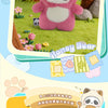 A pink honey bear plush toy surrounded by green grass and trees, with text promoting a panda plush keychain.