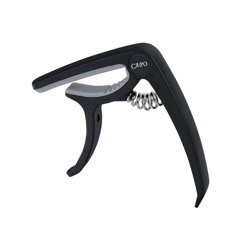 Black adjustable guitar capo with a built-in bridge pin puller tool