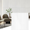 A modern interior featuring a light gray vertical slat wall panel and a brown upholstered chair.