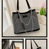 Silver crystal-embellished chain shoulder bag displayed on a white surface.