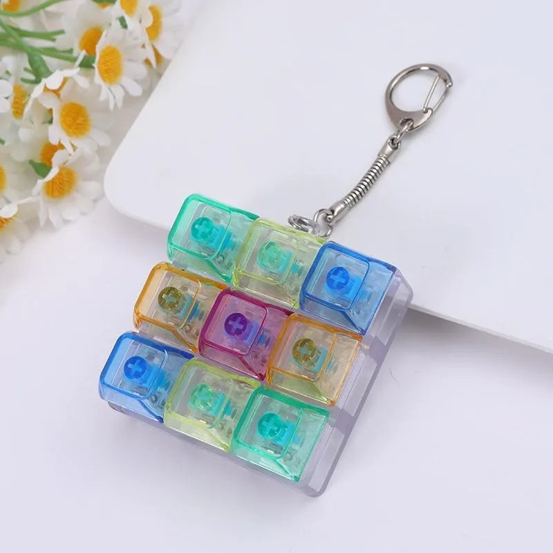 A colorful tactile clicking keyboard fidget toy keychain with multiple translucent colored blocks attached to a silver keyrin