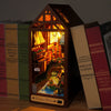 A miniature book nook kit featuring a detailed, illuminated scene of a cozy cottage interior.