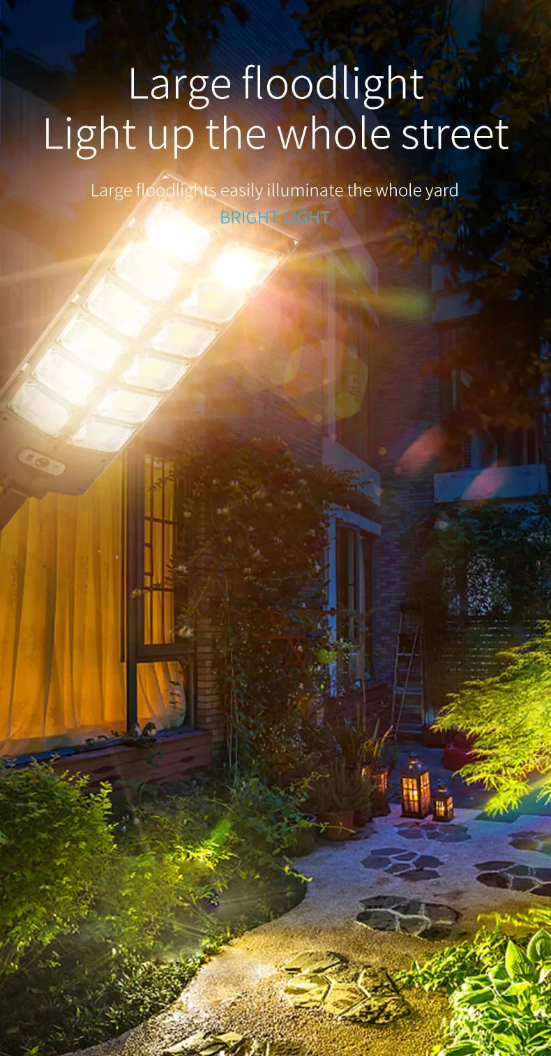 A large floodlight illuminates a garden pathway and foliage at dusk.