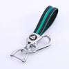 A black and teal TPU leather car key cover with a silver keychain attached.