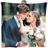A bride and groom embracing in a portrait photo, looking lovingly at each other.