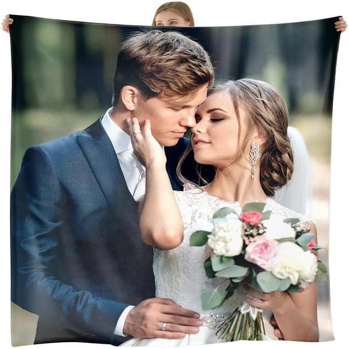 A bride and groom embracing in a portrait photo, looking lovingly at each other.
