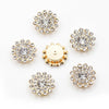 A collection of gold-toned, multi-colored sew-on flower rhinestones in various sizes and shapes.