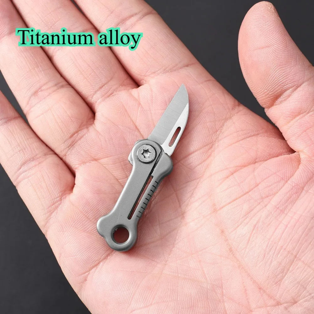 Eine Hand hält ein kompaktes Titan-Taschenmesser mit silberner Klinge und Griff.
