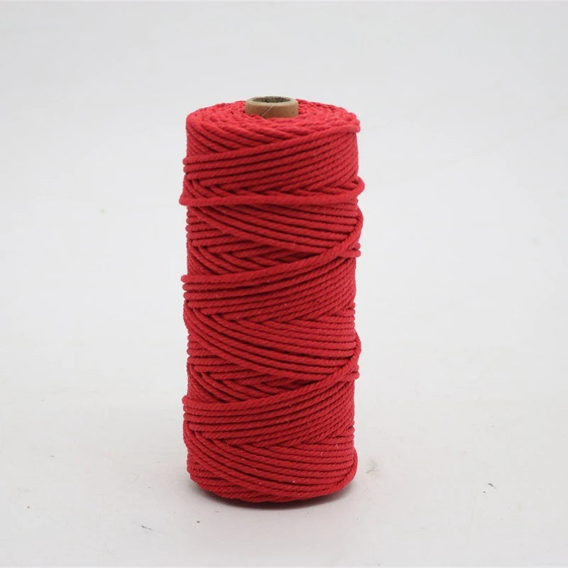 A spool of bright red macrame cord, 3mm/4mm thickness, used for crafting.