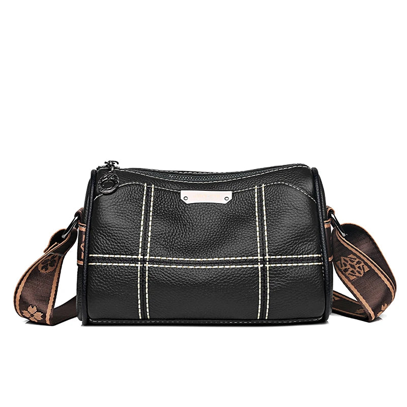 A black vintage genuine leather women's shoulder bag with white stitching and a brown strap.