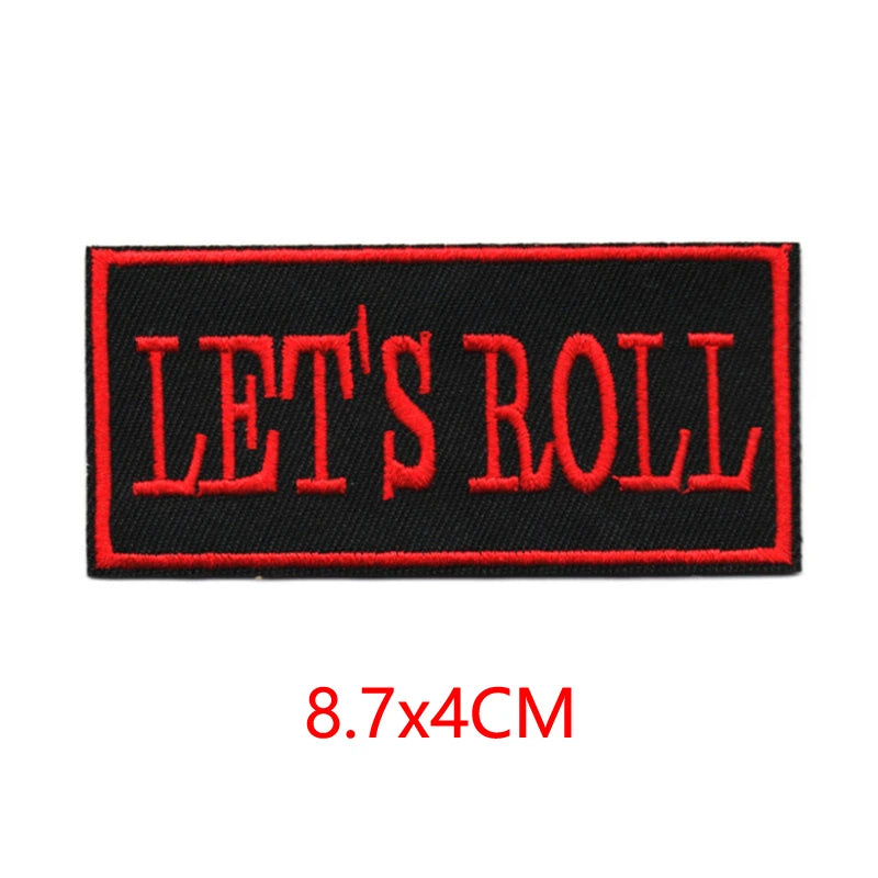 Black embroidered iron-on letter patch with red stitching that reads LET'S ROLL