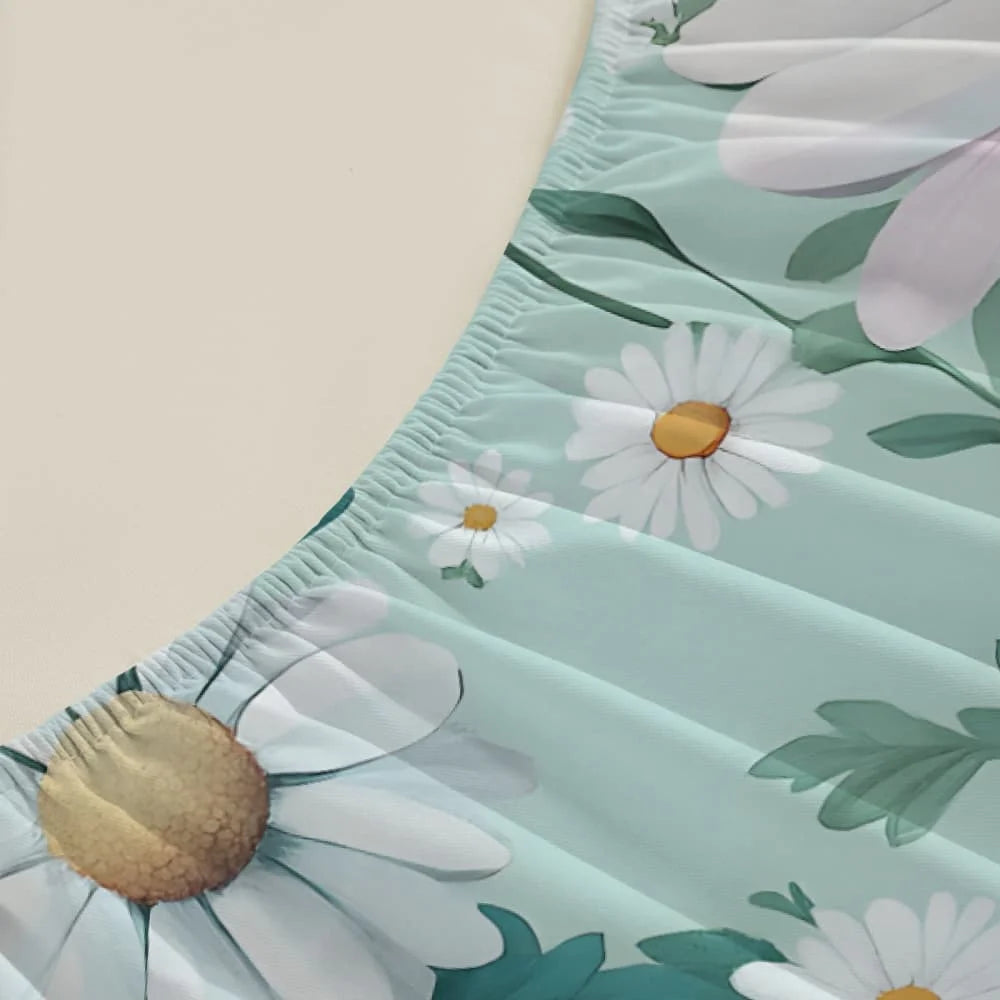 A close-up of a light mint green fitted sheet featuring a white daisy and green leaf floral print.