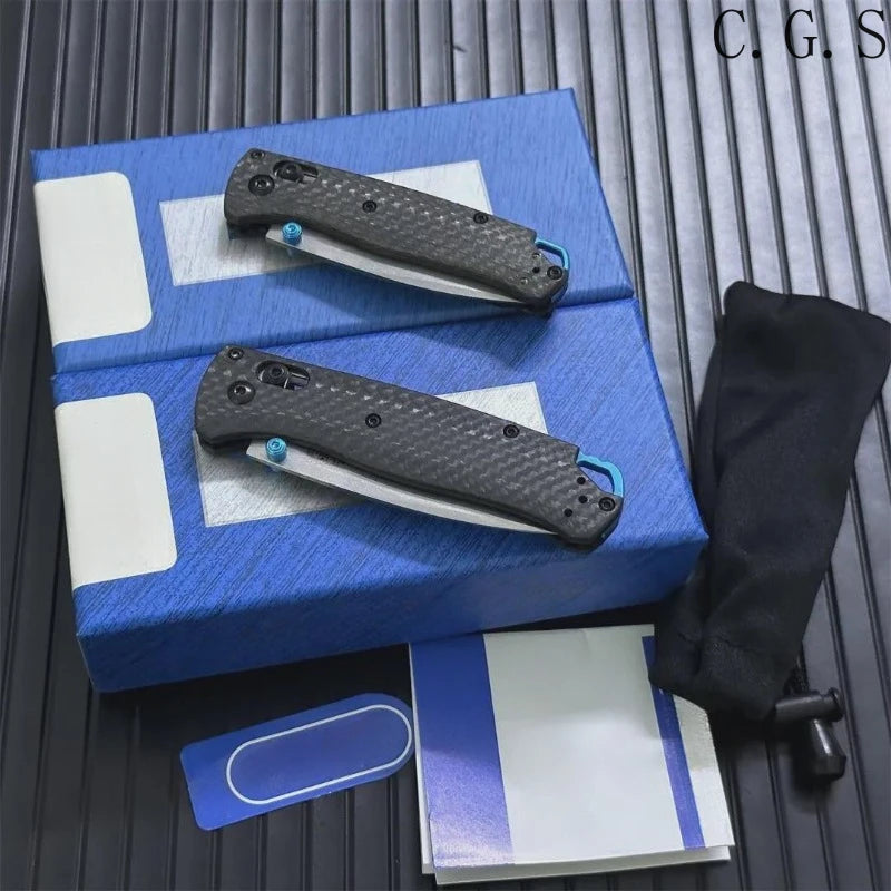 A blue box contains a black carbon fiber folding knife with an axis lock and accompanying paper.