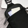Black canvas chest bag with a zipper closure and a pocket for cards