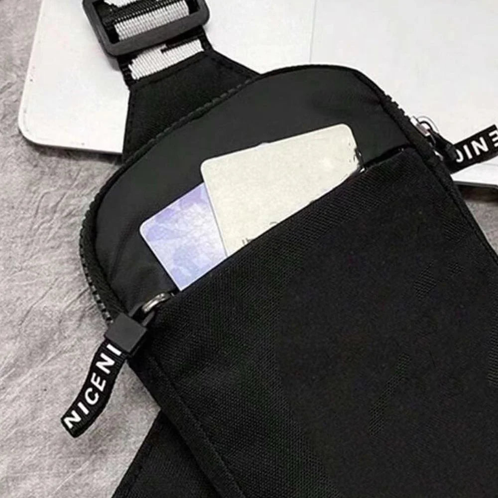 Black canvas chest bag with a zipper closure and a pocket for cards