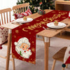 Festive Santa Claus Christmas table runner with red background and gold lettering on a wooden table.