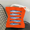 Orange canvas tote bag featuring a repeating blue sardine print.