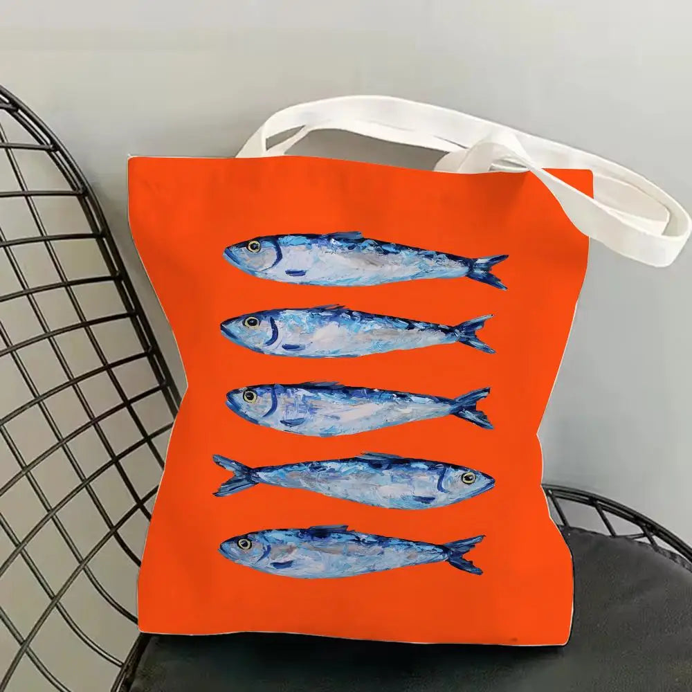 Orange canvas tote bag featuring a repeating blue sardine print.