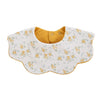 A white muslin cotton baby bib with a yellow lining and adjustable snap closure.