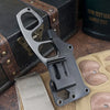 A black compact stainless steel neck knife with a visible opening is shown next to its leather sheath.