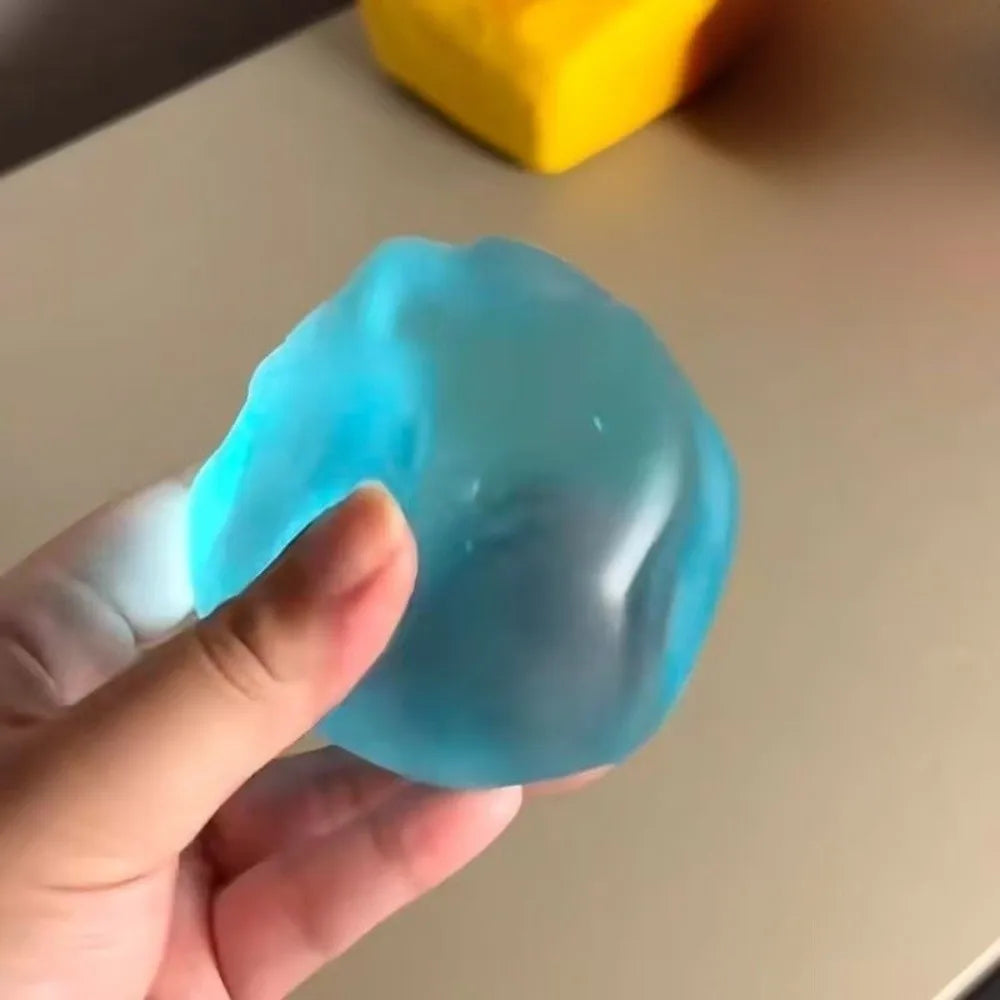 A hand holds a translucent blue stress ball against a light background.