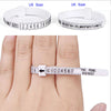 A hand wearing a white adjustable ring sizer measuring tool on a finger.