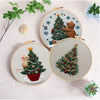 A circular embroidery kit featuring a handcrafted Christmas tree with a bear and festive greenery.