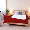 A red stretch-fit box spring cover with an elastic edge is shown on a wooden bed frame.