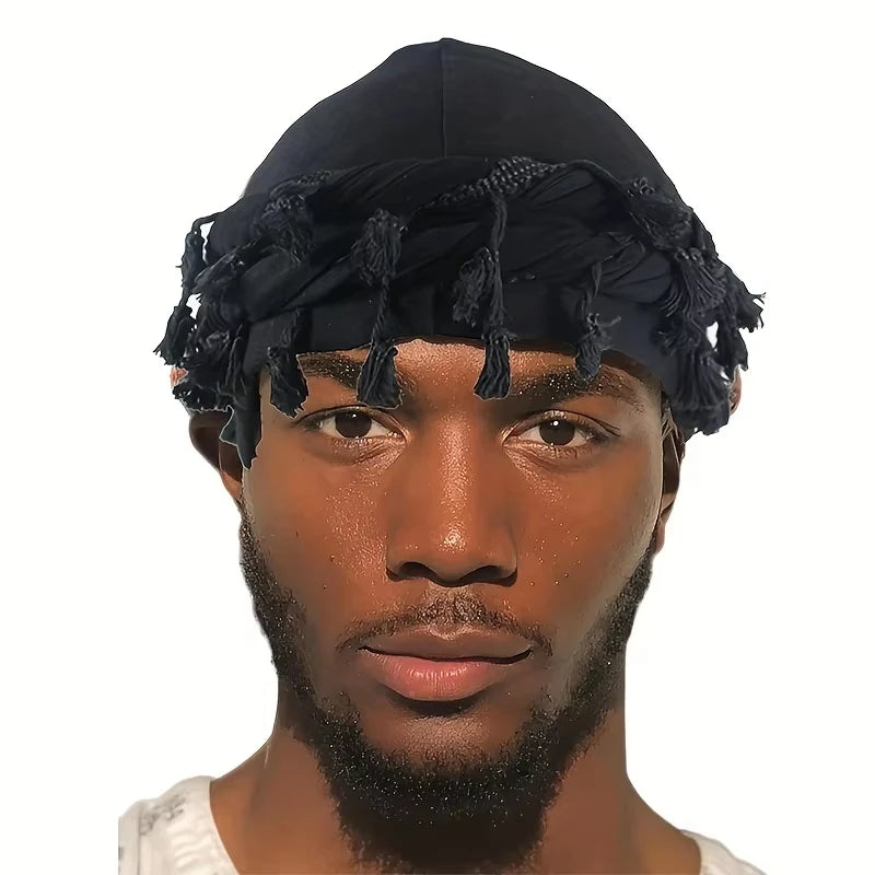 A male model wearing a black vintage twist head wrap with tassels.