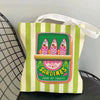 A canvas tote bag featuring a vibrant illustration of three sardines on a green background with vertical stripes.