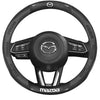 Black carbon fiber and leather steering wheel cover for a Mazda vehicle.