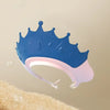 A blue adjustable baby bath shampoo shield cap with ear protection is shown against a beige background.