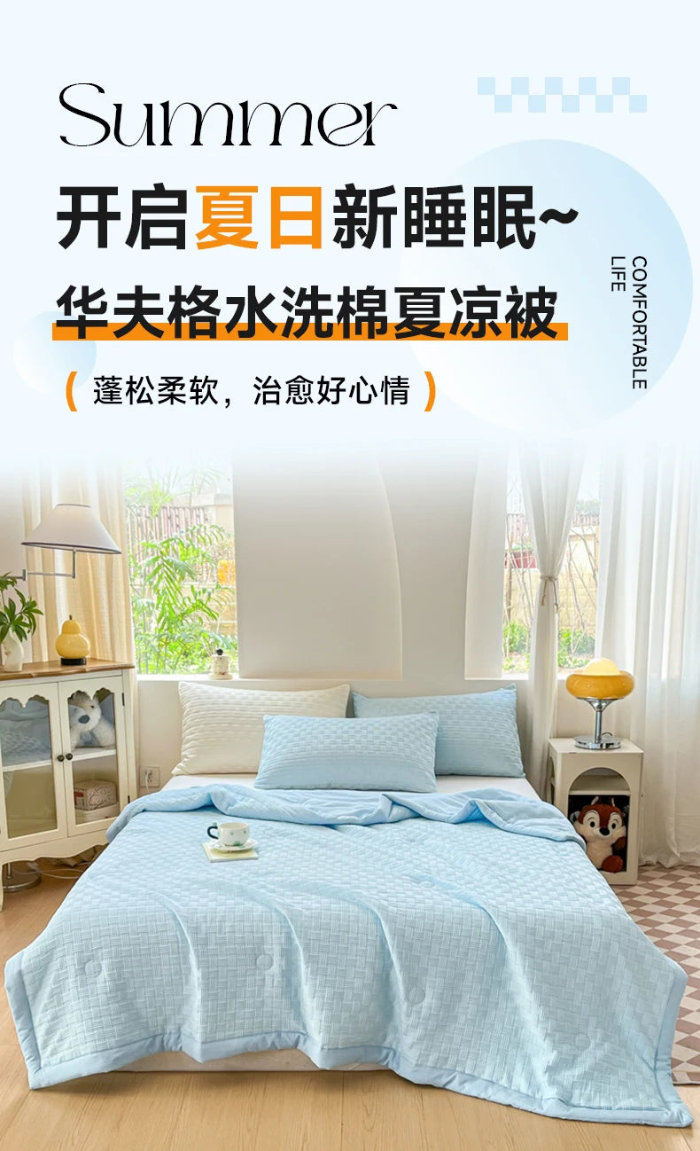 A light blue breathable waffle-weave summer quilt displayed on a bed with white linens and natural light.