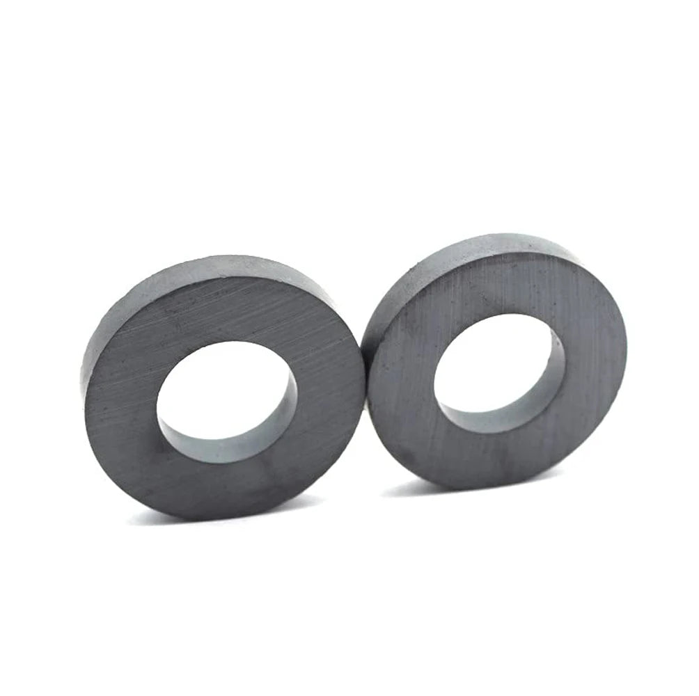 Two industrial-grade ceramic ring magnets with a dark gray finish.