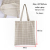 A light grey checkered canvas tote bag with long handles shown in a vertical view.