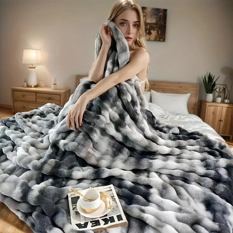 Grau-weißes Kunstfuchs-Fleece-Decke über einem Bett, mit einer Tasse und Untertasse auf dem Stoff.