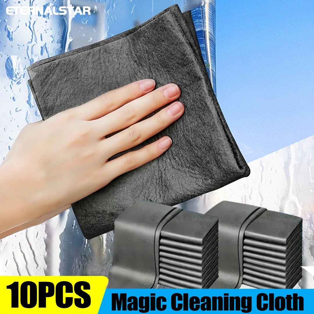 A hand is holding a black microfiber cleaning cloth against a glass surface, demonstrating its use.