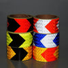 Three rolls of high-visibility reflective safety tape in black, yellow, and red chevron patterns.