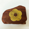 A dark wood slab features a brass design of five overlapping Chinese characters for wealth and home decor.