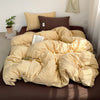 A yellow and beige striped duvet cover set with matching pillows on a brown bed.