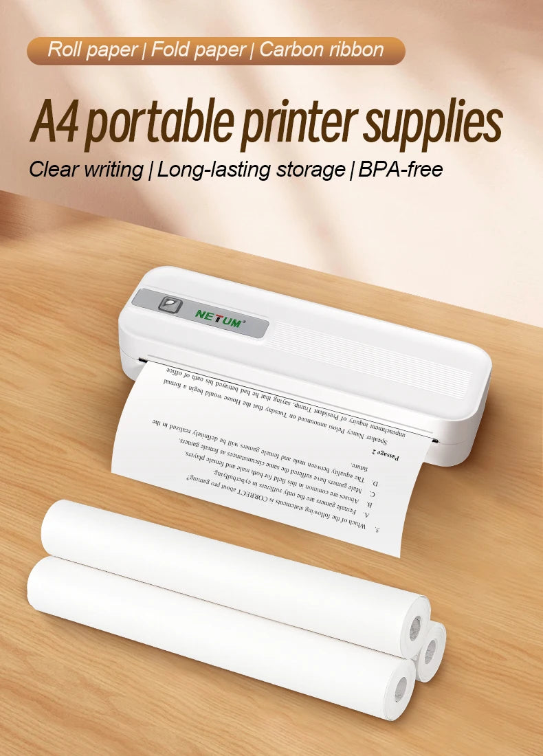 A white portable printer with roll paper and carbon ribbon supplies resting on a wooden surface.