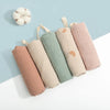A collection of soft cotton gauze burp cloths in various pastel shades, including pink, beige, and mint green.
