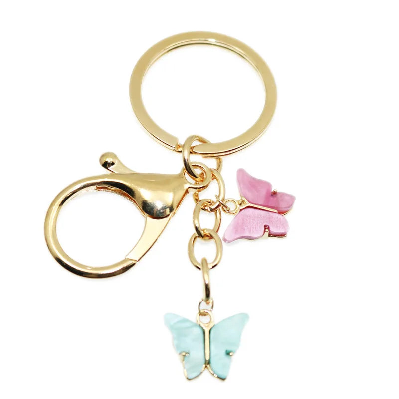 Gold butterfly keychain charm with a pink butterfly detail