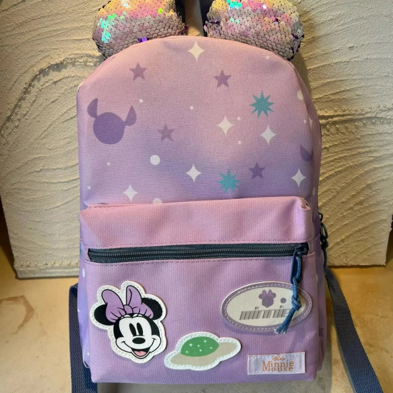 A pink Minnie Mouse themed backpack with cow print accents and a purple strap.