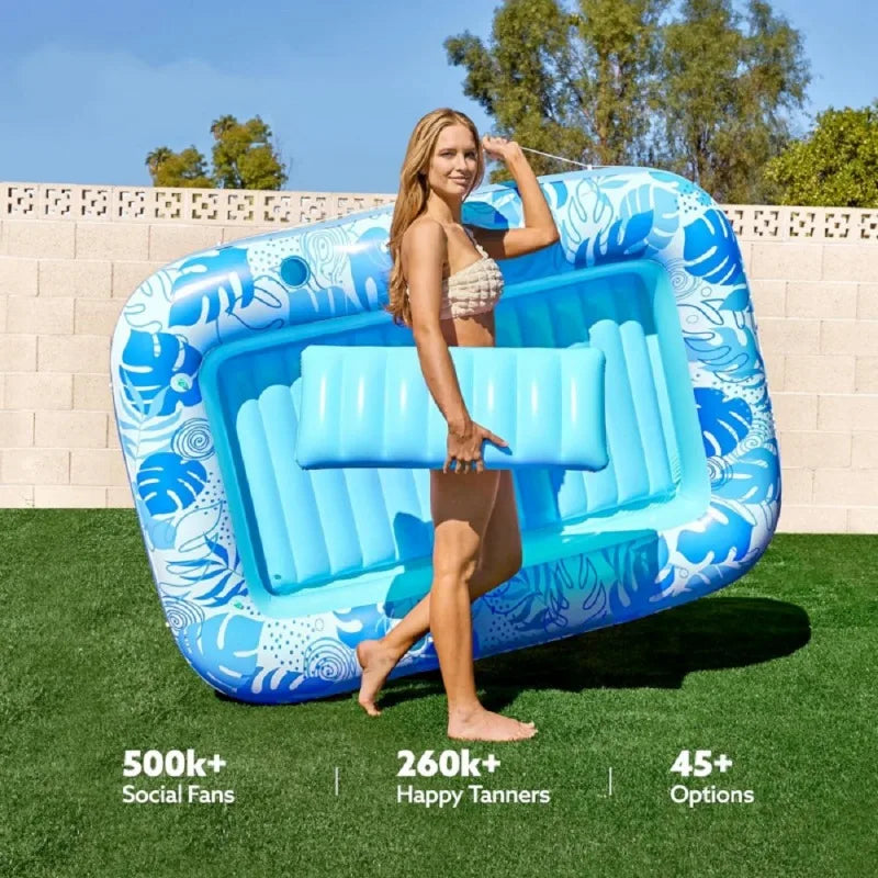 Une femme utilise un transat gonflable bleu avec tête de rechange à l'extérieur sur une pelouse verte.