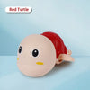 A pink and red wind-up turtle bath toy with a smiling face is shown against a light blue background.