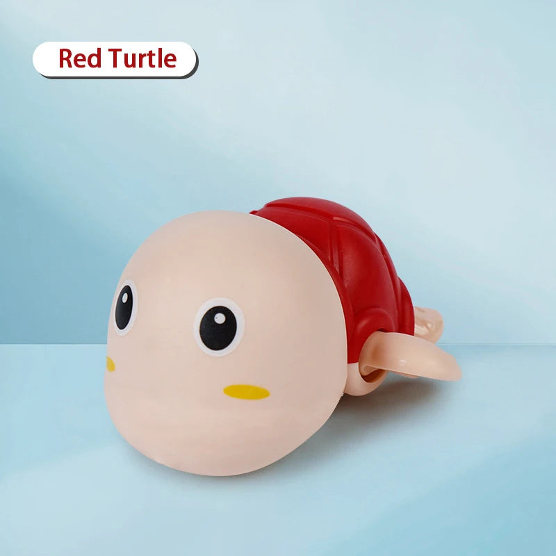 A pink and red wind-up turtle bath toy with a smiling face is shown against a light blue background.
