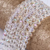 Clear faceted crystal glass spacer beads strung together on a gold textured surface