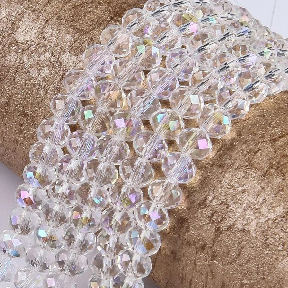Clear faceted crystal glass spacer beads strung together on a gold textured surface