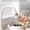 A person is using a kitchen faucet sprayer with a filter to purify water for drinking.
